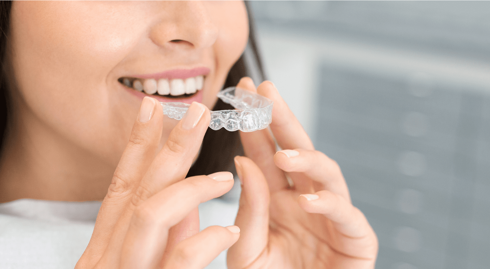 Closeup of woman using invisible braces